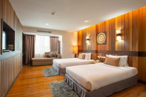 a hotel room with two beds and a couch at Khum Phucome Hotel -SHA Extra Plus in Chiang Mai