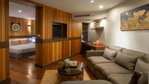 ein Wohnzimmer mit einem Sofa und einem Bett in der Unterkunft Khum Phucome Hotel -SHA Extra Plus in Chiang Mai