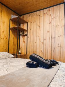 a bedroom with a bed and a wooden wall at Modo- lar mini casa in Penha