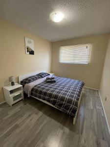 1 dormitorio con 1 cama, mesita de noche y ventana en MT Pleasant NW 2 bedrooms Suite 500AB, en Calgary