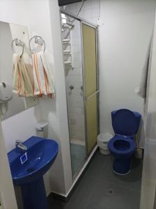 een badkamer met een blauw toilet en een douche bij Los muiscas in Tunja