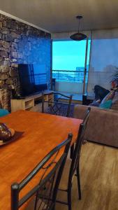 a living room with a wooden table and a couch at Departamento Concón Vista Montemar II in Concón