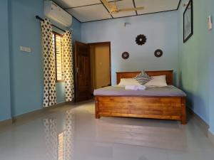 ein Schlafzimmer mit einem Holzbett in einem Zimmer in der Unterkunft Nalluran illam - family room in Jaffna