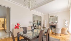 une salle à manger avec une table et des chaises en verre dans l'établissement La Villa d'Auteuil, à Paris