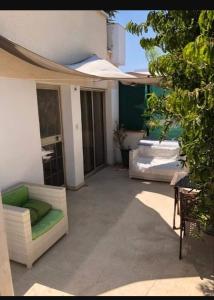 un patio con divano e sedie in un edificio di Golden sunshine a Paralimni