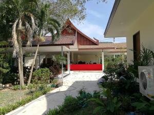 a view of a house with a red front yard at The Casita Phuket (SHA+) in Ban Bo Sai Klang