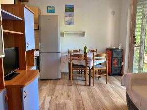 eine Küche und ein Esszimmer mit einem Tisch und einem Kühlschrank in der Unterkunft Apartments with a parking space Silo, Krk - 18729 in Šilo