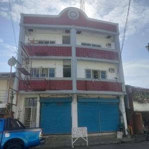 un edificio con puertas de garaje azules delante de él en Pier La Casa Homestay Building, en Surigao