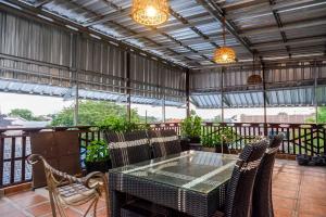 an outdoor patio with a glass table and chairs at RedDoorz Syariah near RS Mitra Keluarga Tegal in Tegal
