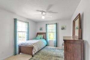 um quarto com uma cama e uma ventoinha de tecto em Seaside Sanctuary close to Navarre Beach! em Navarre
