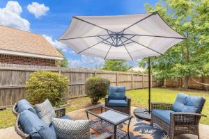 a patio with a table and chairs and an umbrella at Seaside Sanctuary close to Navarre Beach! in Navarre