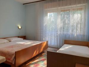 sypialnia z dwoma łóżkami i oknem w obiekcie Apartments with parking spaces Silo, Krk - 18758 w mieście Šilo