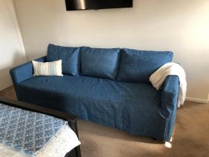 a blue couch with two pillows on it in a room at 5 Star Room with own Bathroom - Singles, Couples, Families or Executives in Glen Waverley