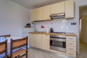 a kitchen with white cabinets and a stove top oven at Apartments by the sea Nerezine, Losinj - 18734 in Nerezine