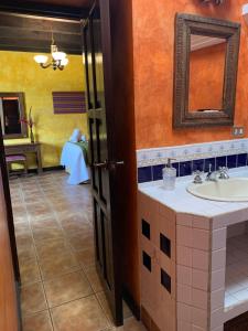 y baño con lavabo y espejo. en Casa El Conquistador, en Antigua Guatemala