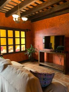 sala de estar con TV de pantalla plana y sofá en Casa El Conquistador, en Antigua Guatemala
