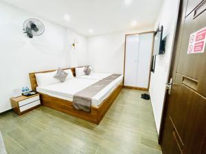 a small bedroom with a bed and a door at Little Vietnam Hotel - Cát Bà in Cat Ba