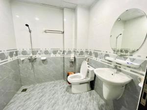 een badkamer met een toilet, een wastafel en een spiegel bij Little Vietnam Hotel - Cát Bà in Cat Ba