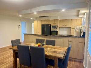 a kitchen and dining room with a wooden table and chairs at Millenium 101 in Forster