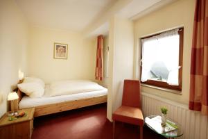Una pequeña habitación con una cama y una ventana. en Hotel Altastenberg, en Winterberg 7 fotos más