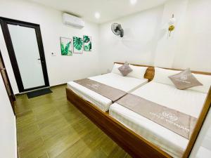 een slaapkamer met een groot bed in een kamer bij Little Vietnam Hotel - Cát Bà in Cat Ba