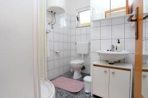 een witte badkamer met een toilet en een wastafel bij Apartments with a parking space Okrug Donji, Ciovo - 18796 in Okrug Gornji