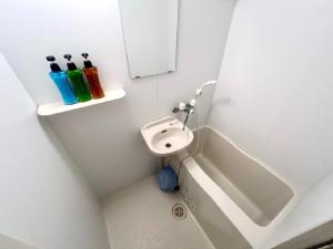 a small white bathroom with a sink and a bath tub at Hamamoto Palace Taniyama - Vacation STAY 11251 in Kagoshima