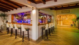 a bar with white stools in a room at Bella Vista Apartments in Pelekas