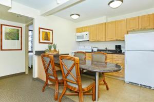 a kitchen with a table and chairs and a refrigerator at Waikiki Sunset #1414 in Honolulu