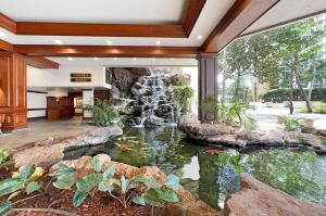 an indoor koi pond in a lobby with a waterfall at Waikiki Banyan #2601-T2 in Honolulu