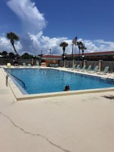 uma piscina com cadeiras e uma pessoa sentada nela em Pelican Inlet C117 condo em Saint Augustine