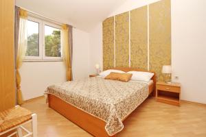 a bedroom with a bed and a window at Apartments with a parking space Baska, Krk - 18794 in Baška