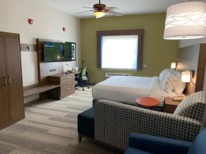 サウス・パドレ・アイランドにあるHoliday Inn Express Hotel and Suites South Padre Island, an IHG Hotelのベッド、ソファ、テレビが備わるホテルルームです。