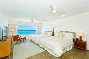 a bedroom with two beds and a large window at Colony Surf #604 in Honolulu