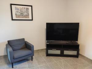a living room with a chair and a flat screen tv at Ferienhaus Blue Pearl in Scharbeutz