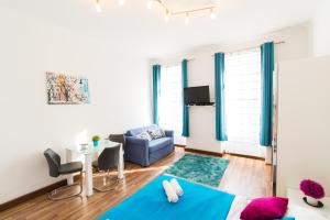 a living room with a blue couch and a table at Apartment Diefenbachgasse in Vienna