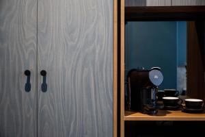 a wooden cabinet with a coffee maker on a shelf at Hotel Alba Adelaide in Adelaide