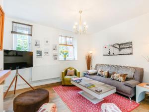 a living room with a couch and a table at Woodlands By The Sea Cottage in Deal