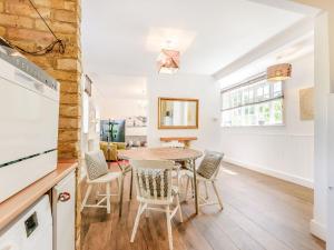 a kitchen and dining room with a table and chairs at Woodlands By The Sea Cottage in Deal