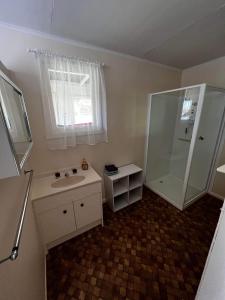 a small bathroom with a sink and a shower at The Crooked Cottage in Murtoa