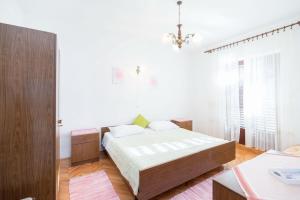 um quarto branco com uma cama e um lustre em Apartments with a parking space Supetar, Brac - 18825 em Supetar