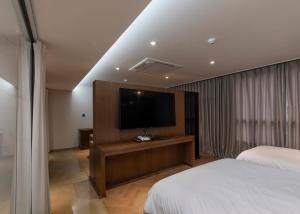 Habitación de hotel con cama y TV de pantalla plana. en Hotel Wolmido en Incheon