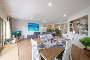 a dining room and living room with a table and chairs at Eagles Nest On Airlie in Airlie Beach