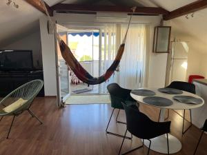 sala de estar con hamaca, mesa y sillas en Apartment Slavica, en Zadar