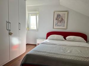 1 dormitorio con 1 cama con cabecero rojo en Apartment Slavica, en Zadar