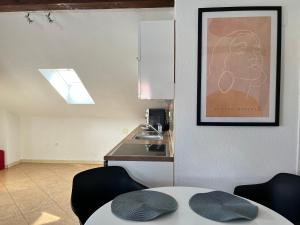 una cocina con mesa y sillas y una foto en la pared en Apartment Slavica, en Zadar