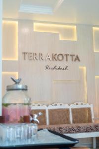 un panneau pour un restaurant avec un pot en verre sur une table dans l'établissement Terrakotta Rishikesh, à Rishikesh