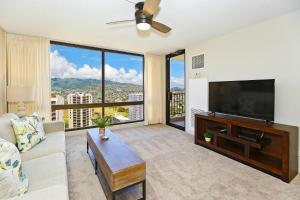 a living room with a large flat screen tv at Waikiki Sunset #2807 in Honolulu