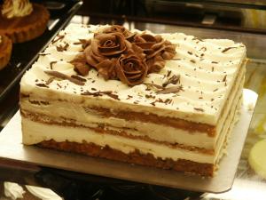 a cake with white frosting and a rose on top at Dolphin SA1 in Swansea