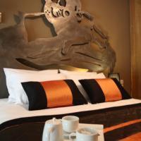łóżko z czarnymi i pomarańczowymi poduszkami i obrazem w obiekcie Mousiko Pandoxeio w mieście Stení Dhírfios